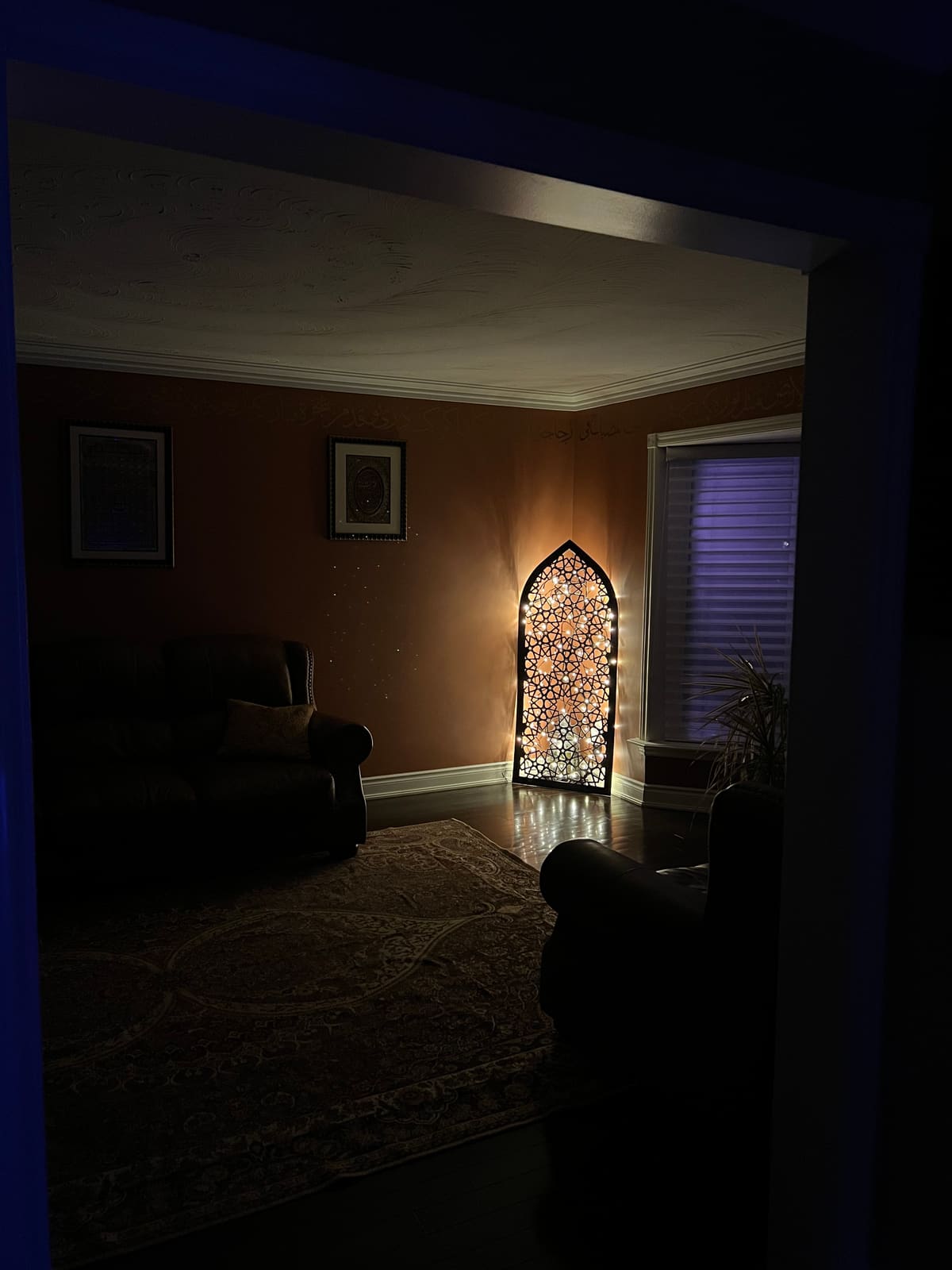 A lit lattice arch in a darkened room